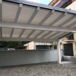 Vista interna di una tettoia in legno bianca con travi a vista