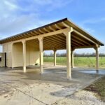 Tettoia in legno chiaro con magazzino integrato e ampio parcheggio esterno