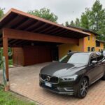 Tettoia in legno scuro per due auto con copertura a falda e struttura robusta